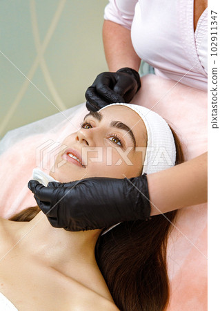 Cosmetic service, Cosmetic therapy, Skin cleansing, Facial therapy, Beauty treatment, Facial rejuvenation treatment, Face massage at the cosmetologist's. Cleansing with cotton pads 102911347