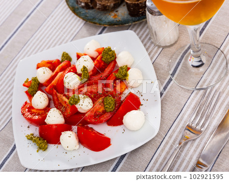 Traditional snack of Italian cuisine is Caprese with basil and Pesto sauce closeup 102921595