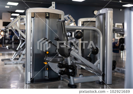 Interior of modern gym with weight training machines 102921689
