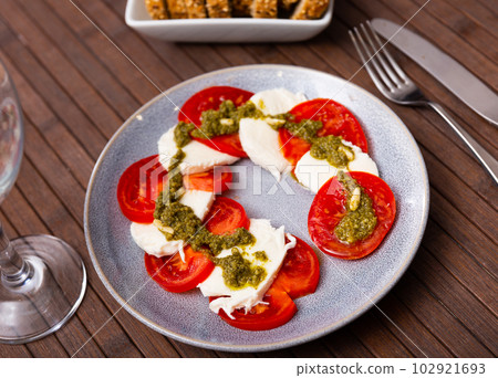 Traditional appetizer of Italian cuisine is Caprese with pesto sauce Traditional appetizer of Italian cuisine is Caprese with pesto sauce 102921693