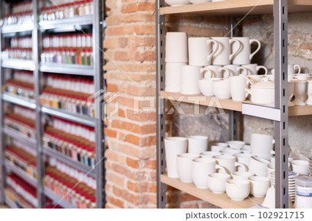 Pottery stands on wooden rack in pottery shop Pottery stands on wooden rack in pottery shop 102921715