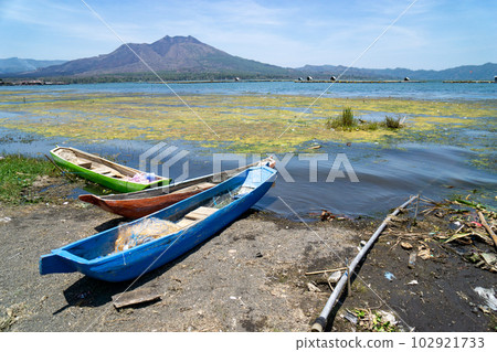Mount Batur and yachts on the shores of Lake Batur in the Kintamani Plateau 102921733