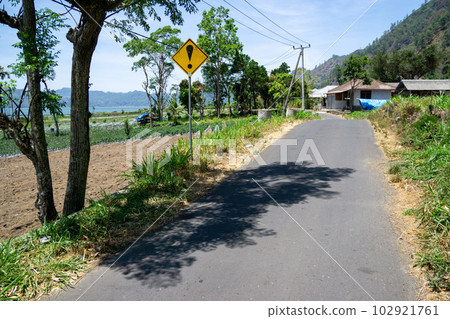 Exclamation mark road sign on the road by Lake Batur Exclamation mark road sign on the road by Lake Batur 102921761