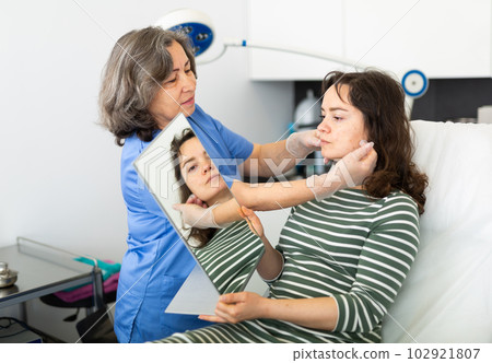 Cosmetologist explains to the patient the procedure of cosmetological operation Cosmetologist explains to the patient the procedure of cosmetological operation 102921807