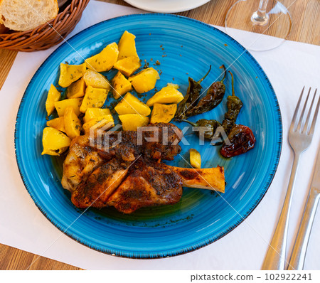 Grilled pork shank with baked potatoes and padron peppers Grilled pork shank with baked potatoes and padron peppers 102922241