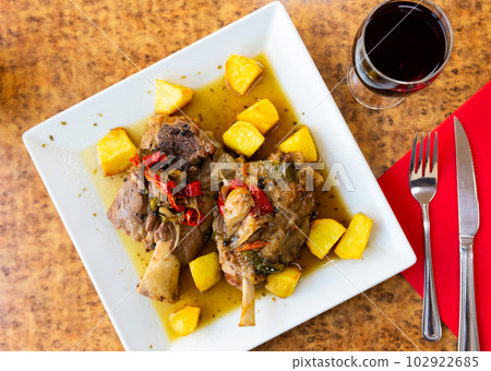 Roasted pork knuckle served with vegetable side dish of potatoes Roasted pork knuckle served with vegetable side dish of potatoes 102922685