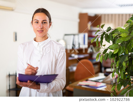 Portrait of woman holding folder in hands 102922786