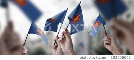 A group of people holding small flags of the ASEAN in their hands 102926062