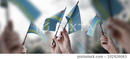 A group of people holding small flags of the Aruba in their hands 102926063