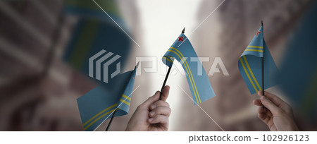 A group of people holding small flags of the Aruba in their hands 102926123