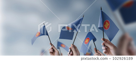 A group of people holding small flags of the ASEAN in their hands 102926189