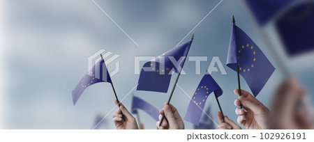 A group of people holding small flags of the European Union in their hands 102926191