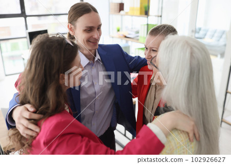Corporate employees hug to support and inspire in office 102926627