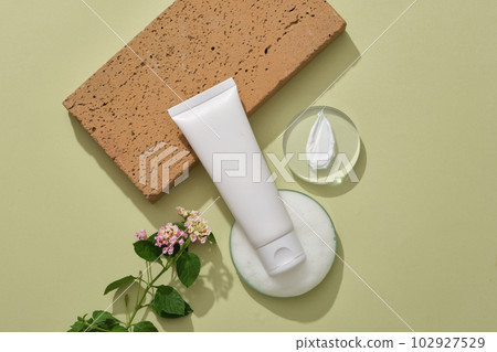 White tube decorated with a glass petri dish of foams, a round podium with cream texture and Lantana camara flowers. Mockup for cleansing product extracted from Lantana camara flower White tube decorated with a glass petri dish of foams, a round podium with cream texture and Lantana camara flowers. Mockup for cleansing product extracted from Lantana camara flower 102927529