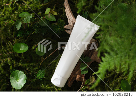 Scene for advertising cosmetic, promote branding with natural concept. White plastic tube container cleanser or moisturizer on forest background with moss, centella and other green leaves 102928213