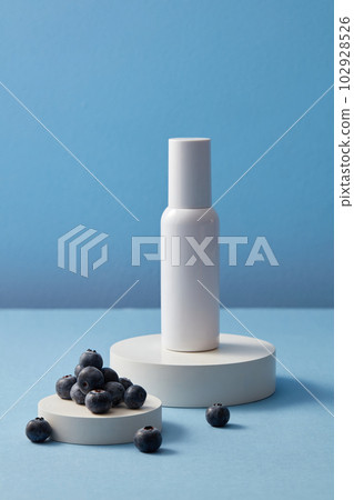Blank label beauty bottle and some blueberries placed on two round white podiums. Blueberry (Vaccinium Corymbosum) brings nutrients and oxygen to your skin Blank label beauty bottle and some blueberries placed on two round white podiums. Blueberry (Vaccinium Corymbosum) brings nutrients and oxygen to your skin 102928526