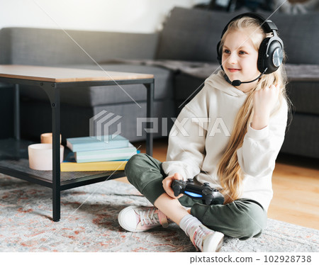 Little girl playing on games console 102928738