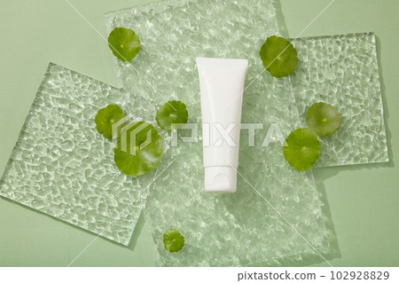 Blank label white tube placed on a rectangle acrylic sheet. Branding mockup. Gotu kola (Centella asiatica) helps strengthen the skin's barrier 102928829