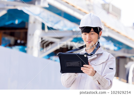 穿著工作服的商人在建築工地看平板電腦 102929254