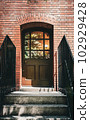 Light pierces red brick and wooden doors 102929428