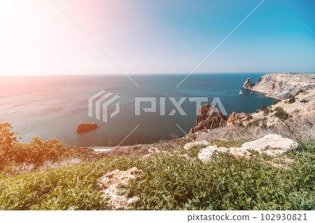 Aerial view from above on calm azure sea and volcanic rocky shores. Small waves on water surface in motion blur. Nature summer ocean sea beach background. Nobody. Holiday, vacation and travel concept Aerial view from above on calm azure sea and volcanic rocky shores. Small waves on water surface in motion blur. Nature summer ocean sea beach background. Nobody. Holiday, vacation and travel concept 102930821