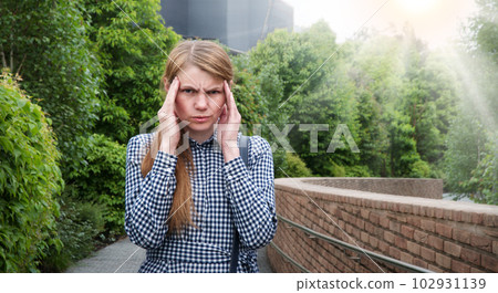 Girl with a headache on the street 102931139