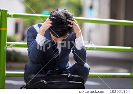 Business Businessman depressed and sitting on the roadside 102931504