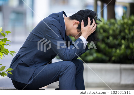 生意人鬱悶坐在路邊 102931511