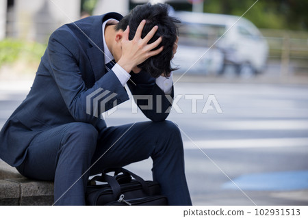 Business Businessman depressed and sitting on the roadside Business Businessman depressed and sitting on the roadside 102931513