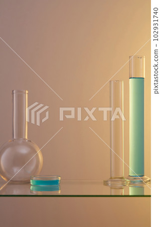 Blue liquid contained inside a tube and glass petri dish over a light background. Empty space for cosmetic product presentation 102931740