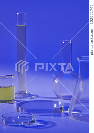 Over a blue background, several laboratory glassware are displayed with a transparent podium. Stage showcase on pedestal Over a blue background, several laboratory glassware are displayed with a transparent podium. Stage showcase on pedestal 102931745