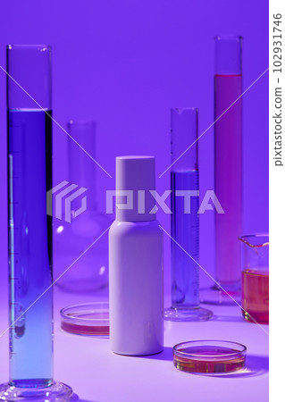 Liquid with blue and pink color contained inside measuring cylinder, beaker and petri dish. Unbranded bottle for mockup Liquid with blue and pink color contained inside measuring cylinder, beaker and petri dish. Unbranded bottle for mockup 102931746