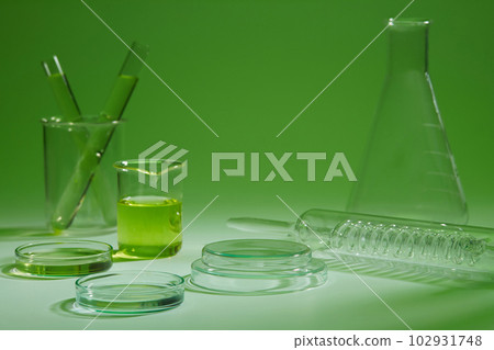 Many laboratory glassware are arranged over a green background. Concept scene stage showcase for product advertising 102931748