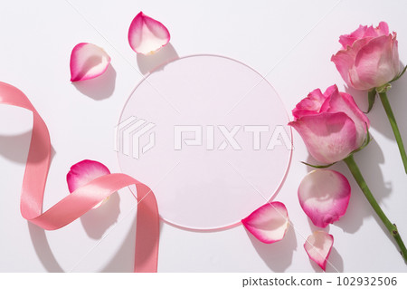 Beauty background with round acrylic sheet form an empty space for display product, fresh roses, ribbon and rose petals decorated on white background. Beauty background with round acrylic sheet form an empty space for display product, fresh roses, ribbon and rose petals decorated on white background. 102932506