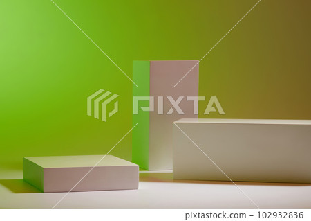 Scene for advertising cosmetic, product display with white geometric podiums arranged on gradient green background. Blank space to place your design 102932836