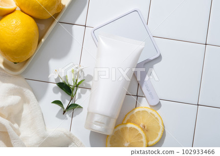 A tray containing Lemons, towel, mirror and a cosmetic container are arranged. Lemon (Citrus limon) is a great way to naturally cleanse your skin and make it look healthier 102933466