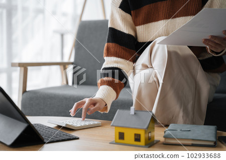 Tenant woman holding paper ticket using calculator for business finance accounting calculate bank loan rent payment manage finance expenses tax making documents concept. 102933688