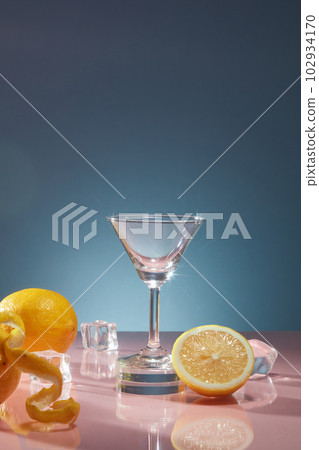 Glass cup with ices and fresh lemons decorated on dark blue background. Scene for advertising beverage products with fresh lemon flavor for a refreshing feeling Glass cup with ices and fresh lemons decorated on dark blue background. Scene for advertising beverage products with fresh lemon flavor for a refreshing feeling 102934170