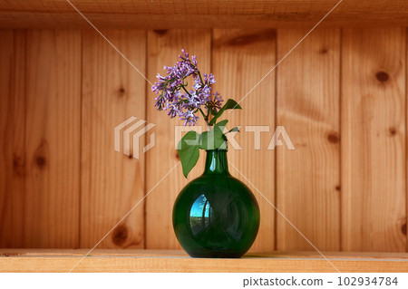 One vase with flowers at wooden background from side view One vase with flowers at wooden background from side view 102934784