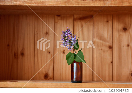 One vase with flowers at wooden background from side view One vase with flowers at wooden background from side view 102934785
