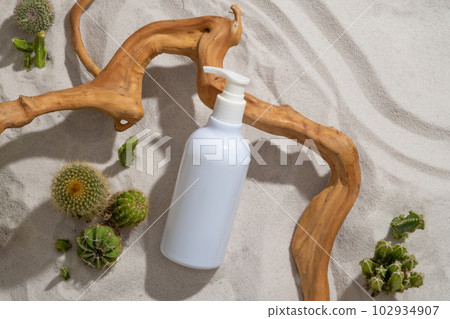 An unlabeled bottle in white color is leaning on a tree branch. Container packaging of skin care branding. Product mockup 102934907
