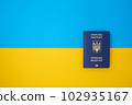 One blue Ukrainian biometric passport on the Ukrainian national flag in the top view 102935167