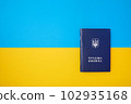 One blue Ukrainian work book on the Ukrainian national flag in the top view 102935168