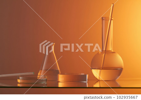 Laboratory glassware and glass rod decorated with a round transparent podium. Gradient orange background. Modern minimal showcase scene for cosmetic products promotion 102935667