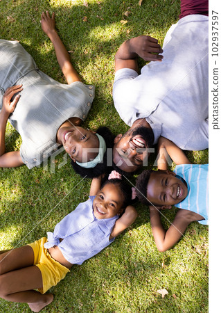 High angle view of happy african american parents and children lying on grassy land in park 102937597