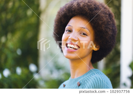 Portrait of happy african american woman looking at camera and smiling in garden 102937756
