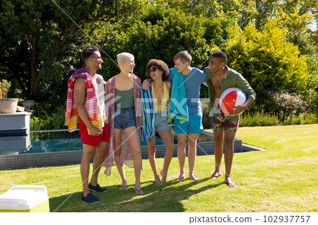 Happy diverse group of friends having pool party, embracing and smiling in garden 102937757