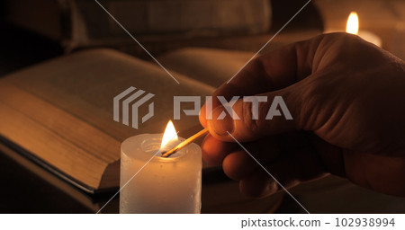 Hand lights a candle Hand lights a candle 102938994
