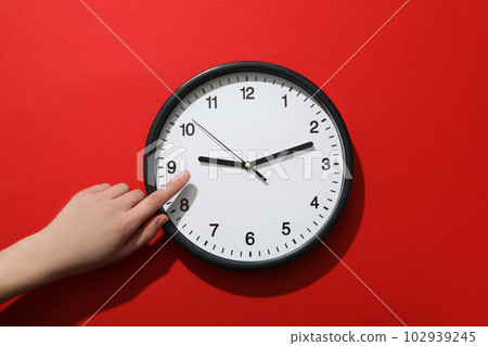 Concept of time change with clock on red background Concept of time change with clock on red background 102939245