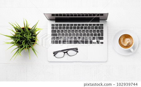 Office desk table with laptop, cup of coffee and supplies Office desk table with laptop, cup of coffee and supplies 102939744